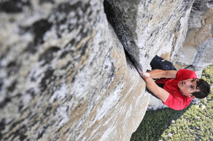 A mountain climber ascends a mountain to its peak